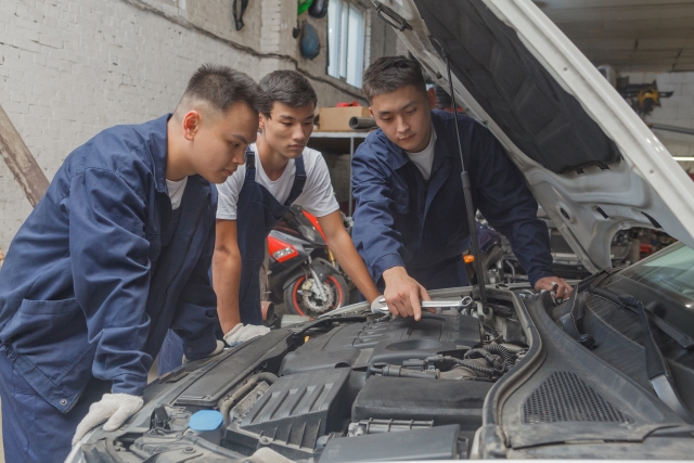 車の整備をする3人の男性